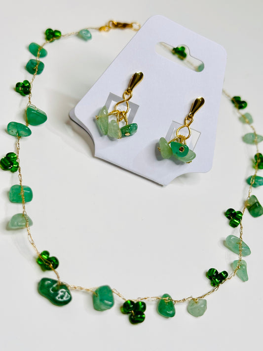 Green gemstone necklace and earrings on a white card with a white background