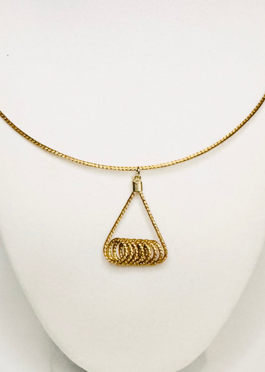 Handwoven golden grass pendant detail made by quilombola community