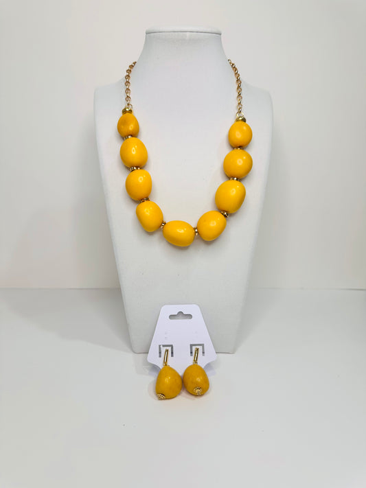 Yellow necklace and earrings set on a white background