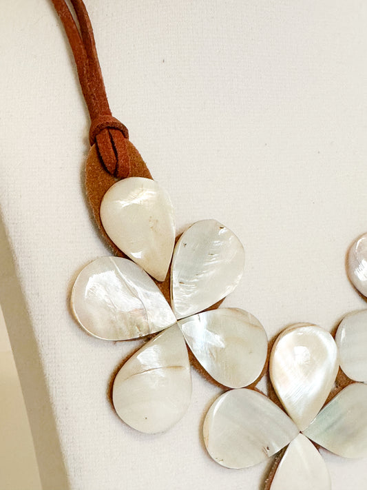 Mother of pearl shell flower necklace mounted on suede backing.