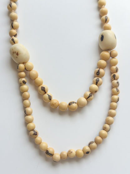 Amazonian necklace showing natural bead variations made from açaí seeds and paxiúba wood.