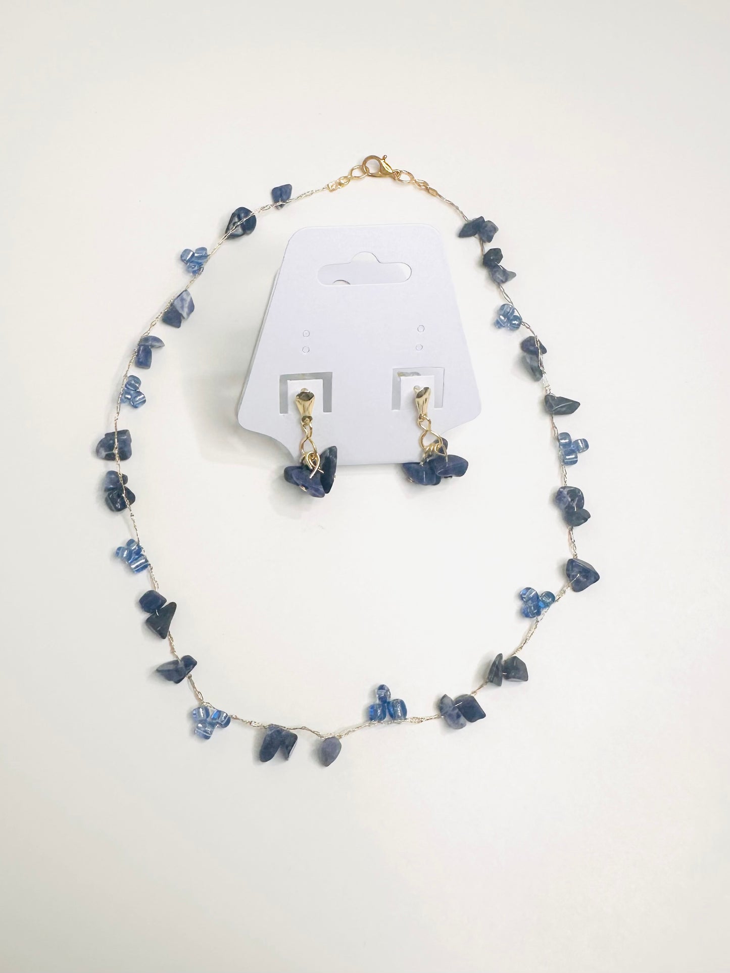 Blue Jewelry set with necklace and earrings on a white background