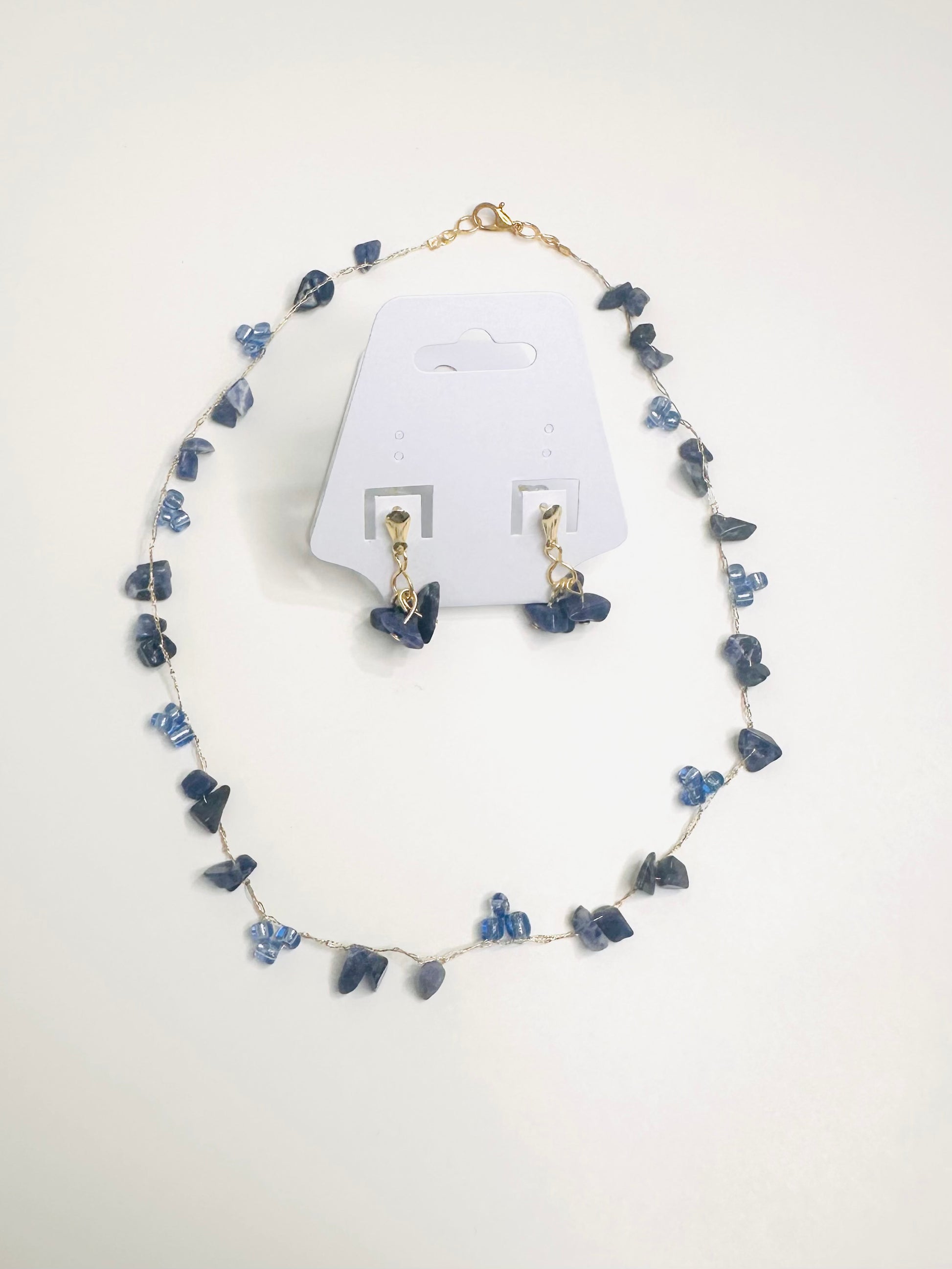 Blue Jewelry set with necklace and earrings on a white background