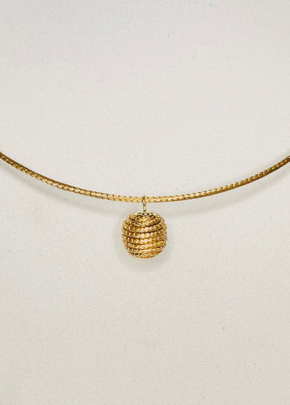 Minimalist golden grass pendant woven from capim dourado