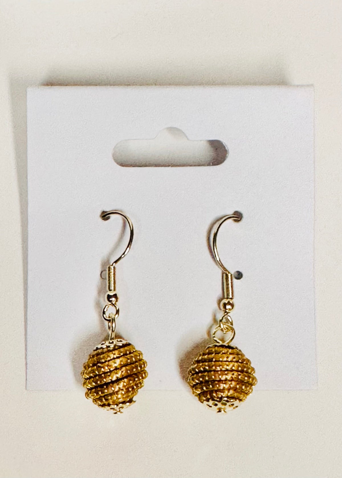 Golden grass earrings handmade in Brazil by quilombola community