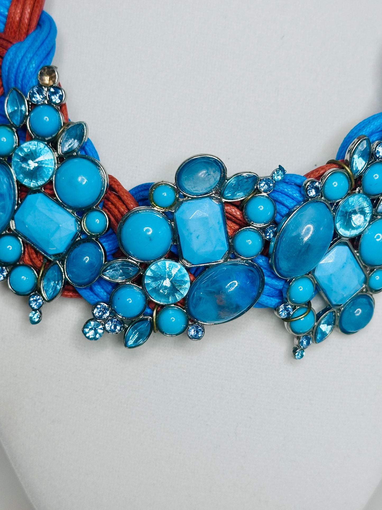 Azul Fogo braided cotton statement necklace featuring blue and orange twisted strands with layered turquoise-tone bead detail close-up