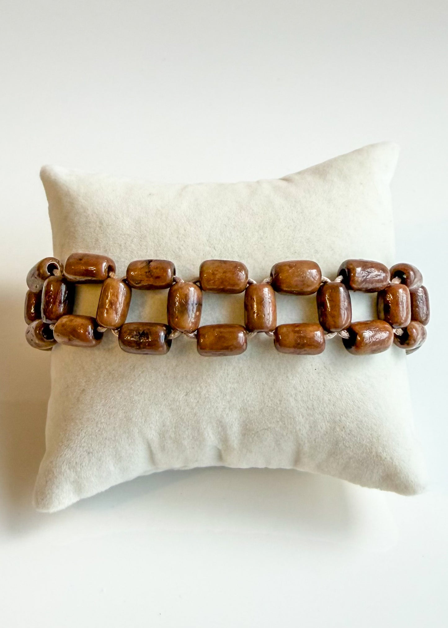 Brown Açaí Mosaic Bracelet displayed on cream jewelry cushion
