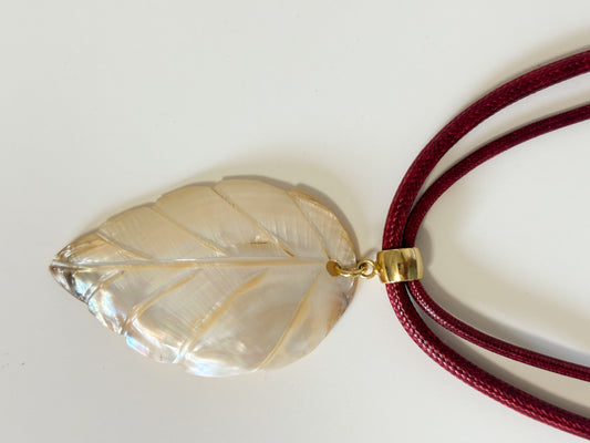 Carved mother of pearl leaf pendant from Amazon river shell.