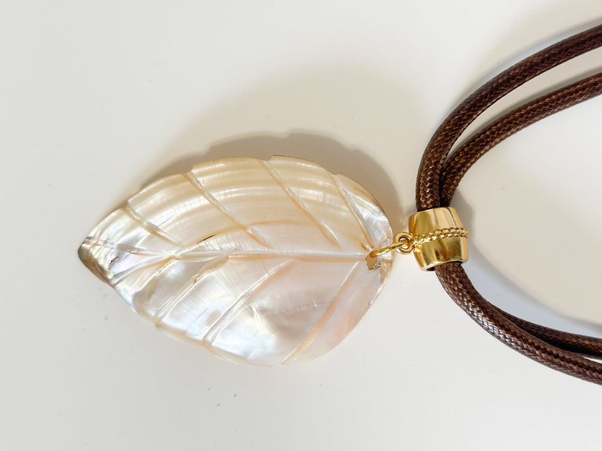 Carved mother of pearl leaf pendant from Amazon river shell close-up