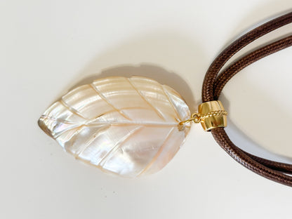 Carved mother of pearl leaf pendant from Amazon river shell close-up