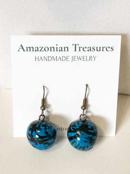 Close-up Blue jarina seed earrings handcrafted with vegetable ivory.