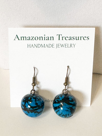 Close-up Blue jarina seed earrings handcrafted with vegetable ivory.