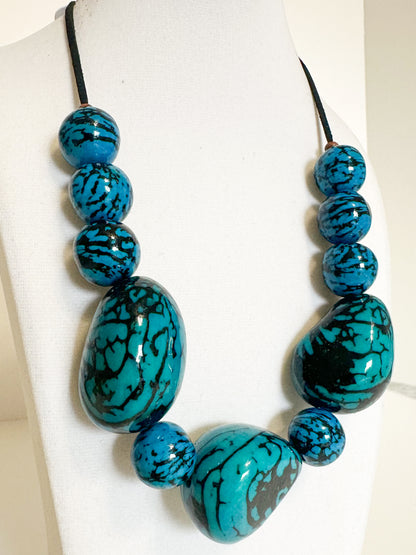 Close-up Blue jarina seed necklace handcrafted with vegetable ivory.