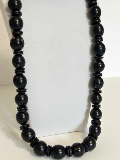Close-up Natural tucumã seed necklace with colorful accents and coconut shell beads.