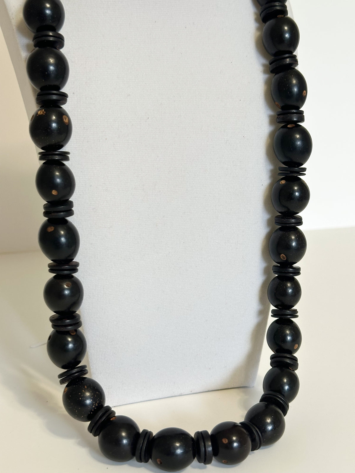 Close-up Natural tucumã seed necklace with colorful accents and coconut shell beads.