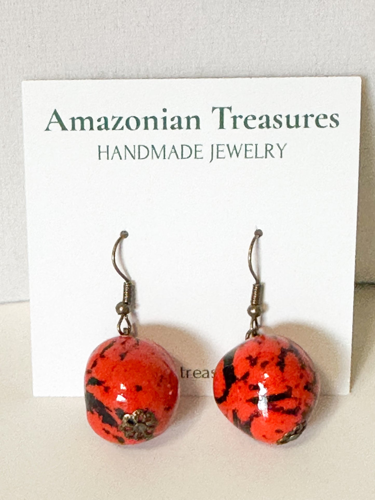 Close-up Orange dyed jarina bead earrings made by Brazilian artisan.