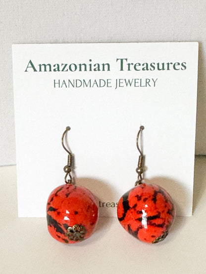 Close-up Orange dyed jarina bead earrings made by Brazilian artisan.