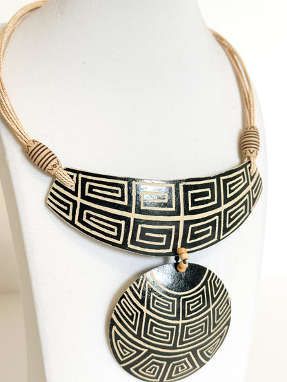 Close-up of cuia gourd pendant featuring Indigenous-inspired Amazon patterns