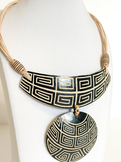 Close-up of cuia gourd pendant featuring Indigenous-inspired Amazon patterns