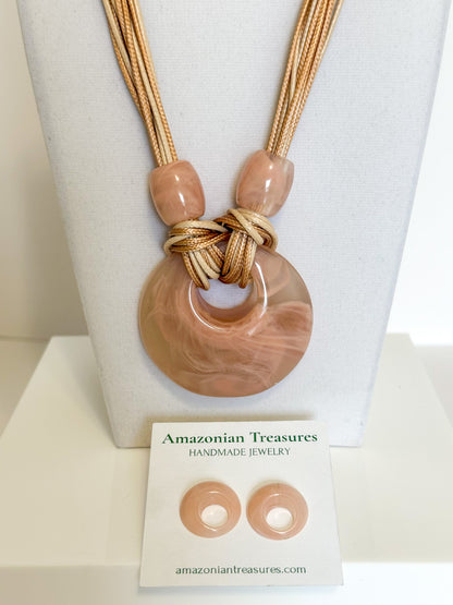 Close-up of pink resin circle pendant with cotton cord necklace.