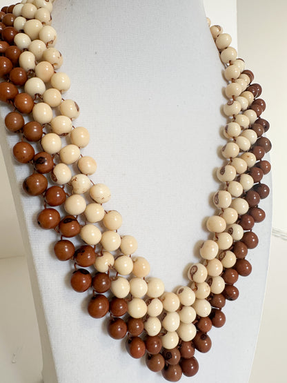 Close-up of polished dyed açaí seeds used in handmade Brazilian necklace.