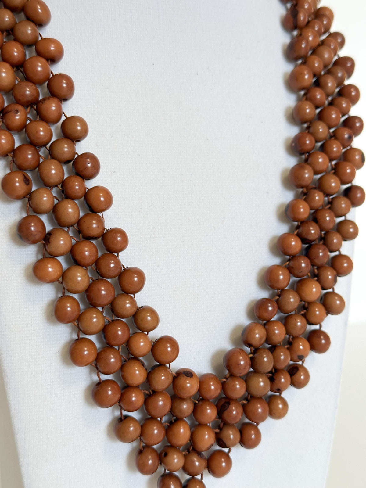 Close-up of polished dyed açaí seeds used in handmade Brazilian necklace. Brown