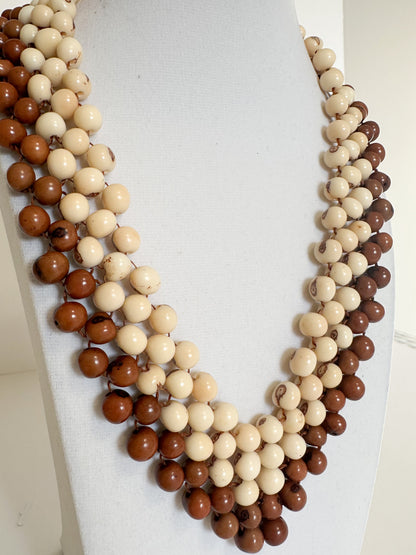Close-up of polished dyed açaí seeds used in handmade Brazilian necklace.