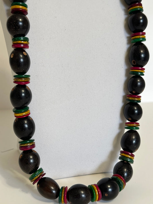 Close-up of polished tucumã seeds with coconut shell beads in handmade necklace.
