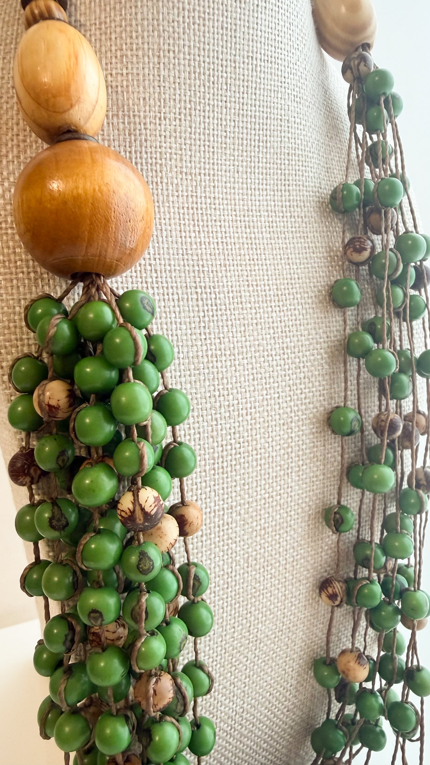 Close-up of reclaimed wood and green tinted Açaí seeds on Brazilian artisan necklace