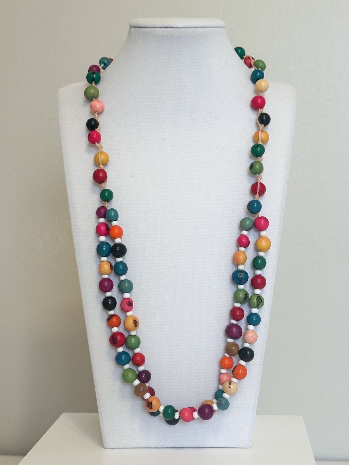 Colorful açaí seed necklace with white beads handcrafted by an Indigenous Amazon community.