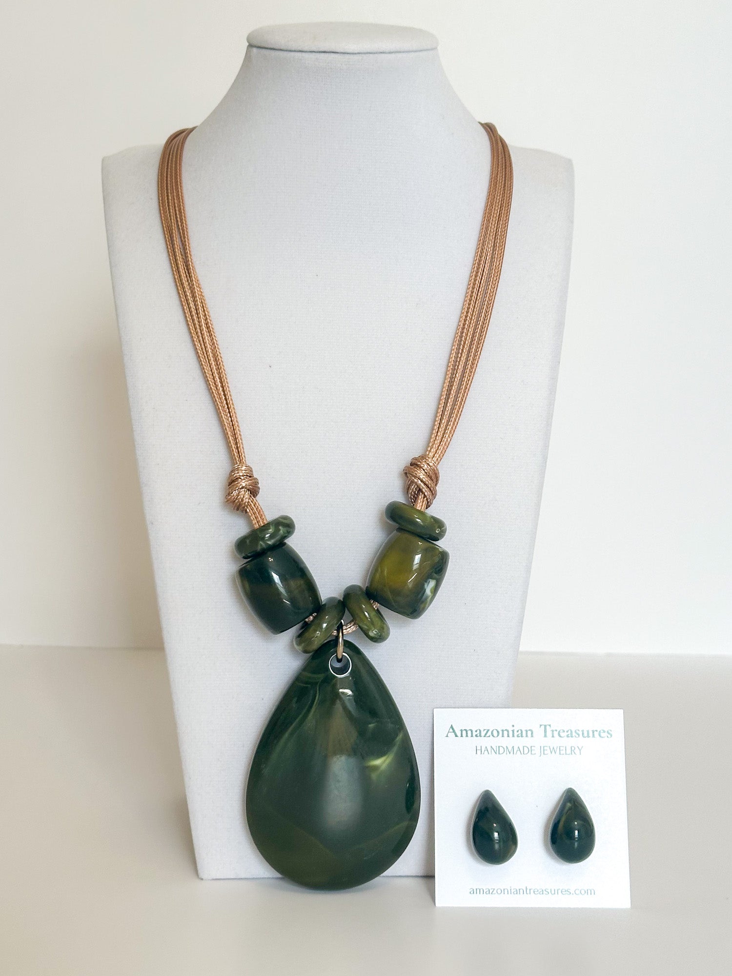 Cotton cord necklace with green resin drop pendant and matching resin earrings designed by a Brazilian jewelry studio.