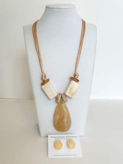 Cotton cord necklace with resin drop pendant and matching resin earrings designed by a Brazilian jewelry studio.