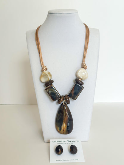 Cotton necklace with dark resin pendant and coordinating resin earrings.