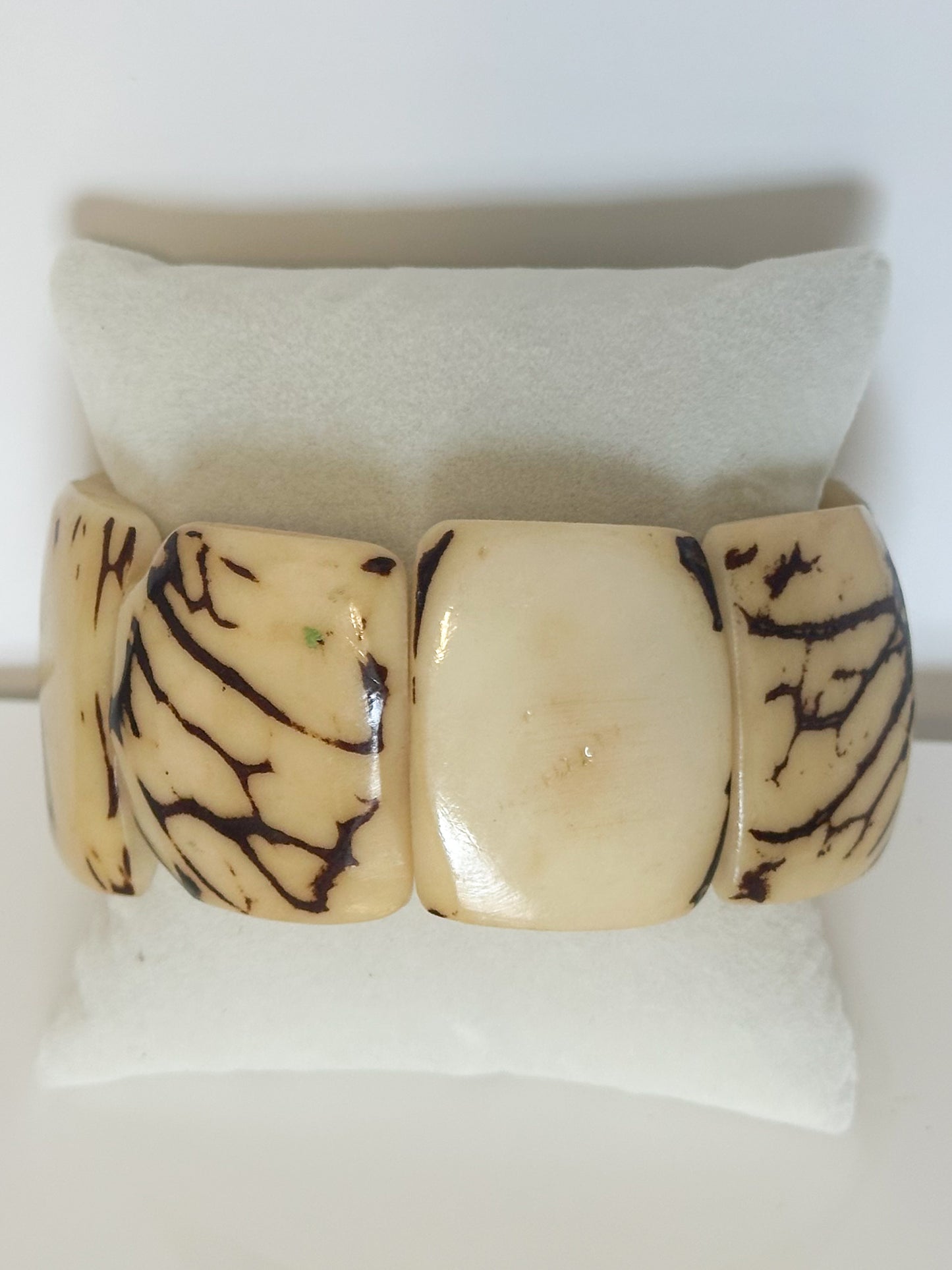 Cream dyed jarina tagua stretch bracelet with natural seed patterns.