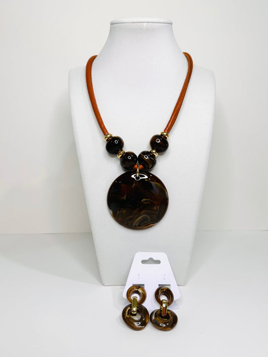 Necklace with brown beads and leather strap on a white mannequin bust, accompanied by matching earrings.