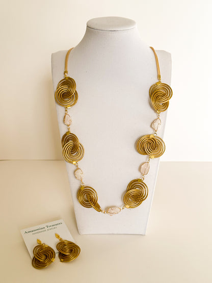 Espiral Dourada Set featuring golden grass spiral necklace and matching earrings handcrafted by quilombola artisans in Brazil.