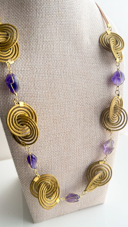 Espiral Dourada Set featuring golden grass spiral necklace and matching earrings handcrafted by quilombola artisans in Brazil  Amethyst detail
