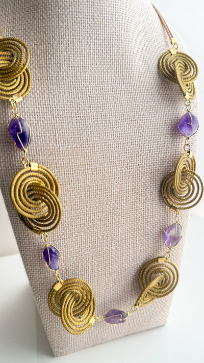 Espiral Dourada Set featuring golden grass spiral necklace and matching earrings handcrafted by quilombola artisans in Brazil  Amethyst detail