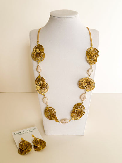 Espiral Dourada Set featuring golden grass spiral necklace and matching earrings handcrafted by quilombola artisans in Brazil.