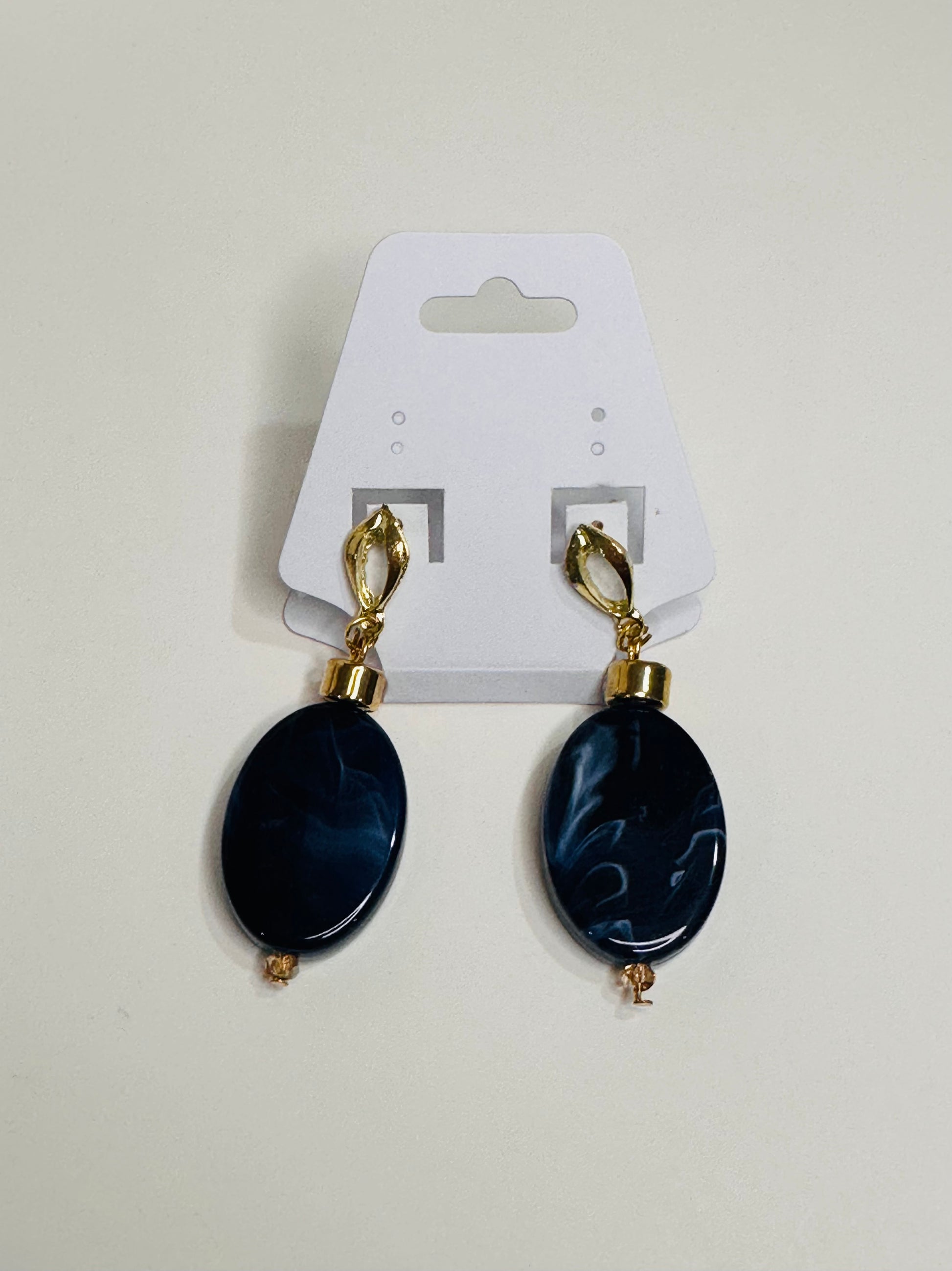 Pair of blue oval earrings with gold accents on a white card.
