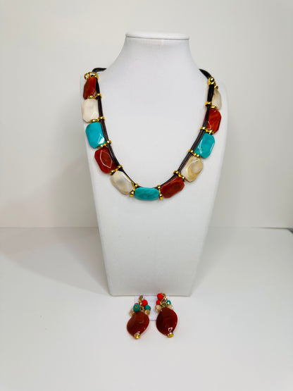 Necklace and earrings with multicolored resin on a white stand