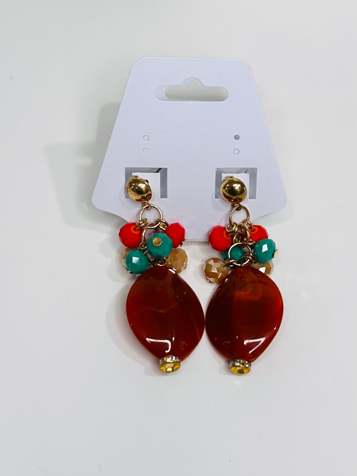 Pair of earrings with brown beads and colorful accents on a white card.