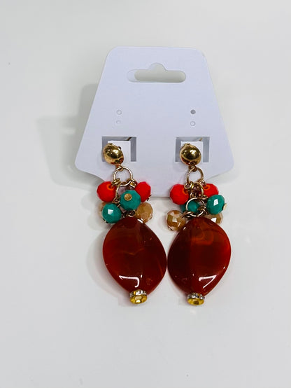 Pair of earrings with brown beads and colorful accents on a white card.