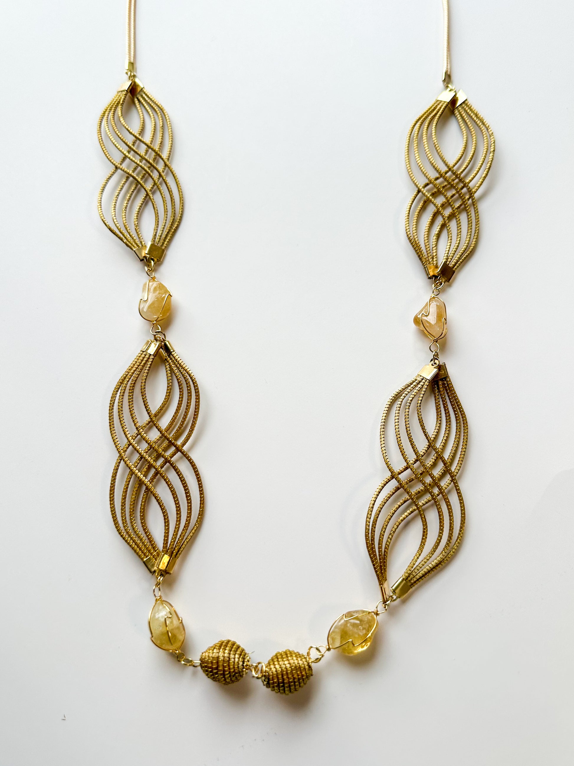 Golden grass flowing necklace with citrine gemstone handcrafted by quilombola artisans.