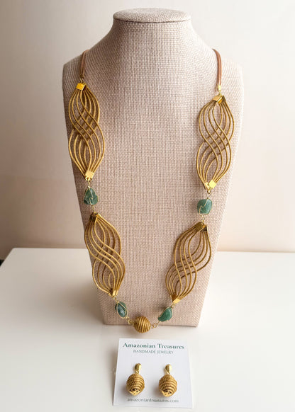Golden grass flowing necklace with green gemstone handcrafted by quilombola artisans.