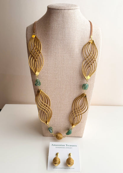 Golden grass flowing necklace with green gemstone handcrafted by quilombola artisans.