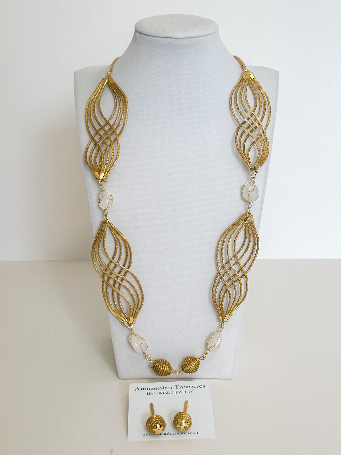 Golden grass flowing necklace with white gemstone handcrafted by quilombola artisans.