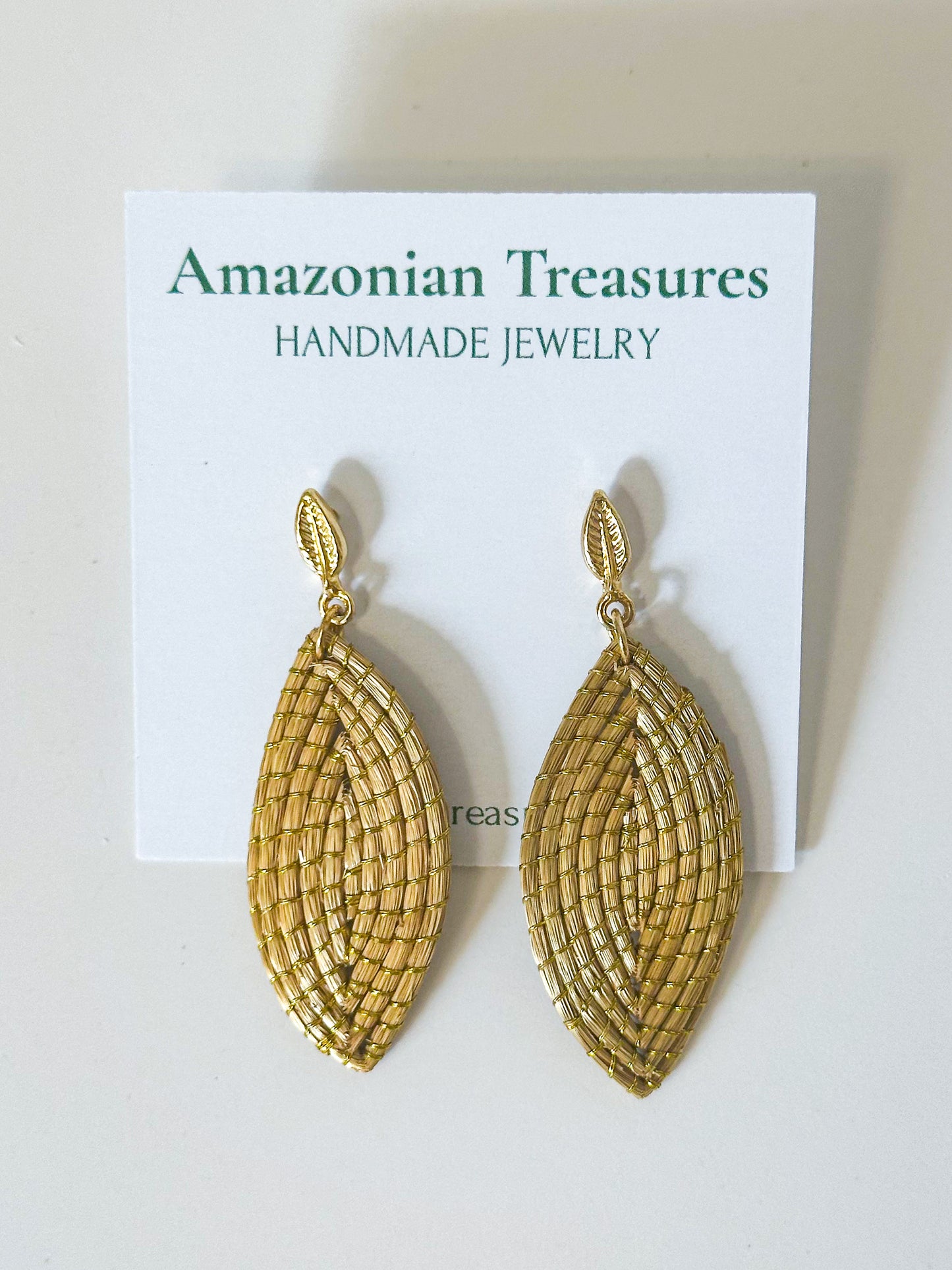 Golden grass leaf earrings handcrafted by quilombola artisans using capim dourado.