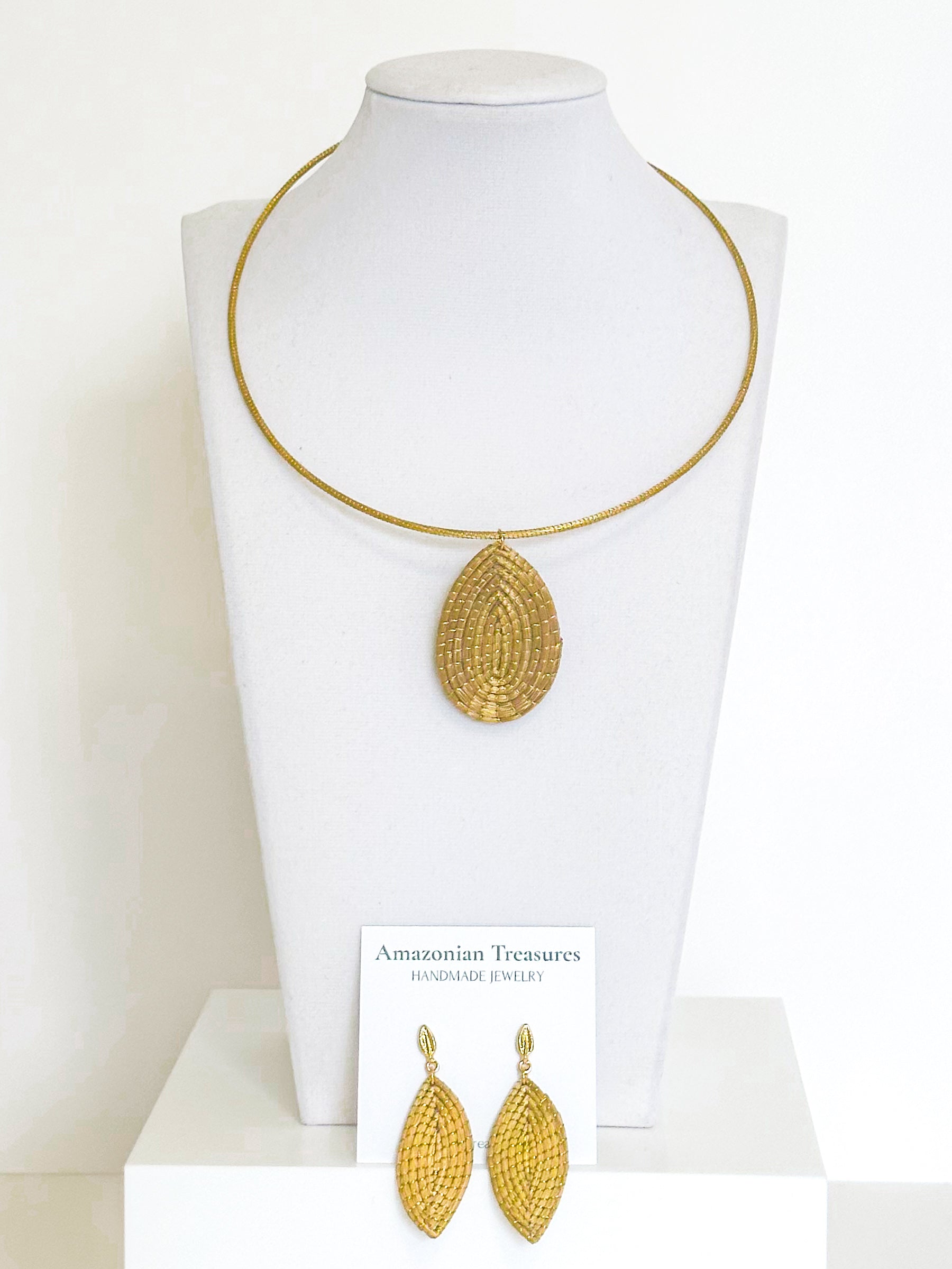 Golden grass leaf necklace and earrings set handcrafted by quilombola artisans using capim dourado.