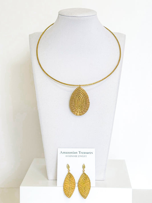 Golden grass leaf necklace and earrings set handcrafted by quilombola artisans using capim dourado.